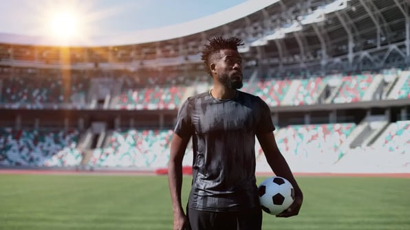 Futbolista conduce el balón durante un partido en un estadio de fútbol profesional