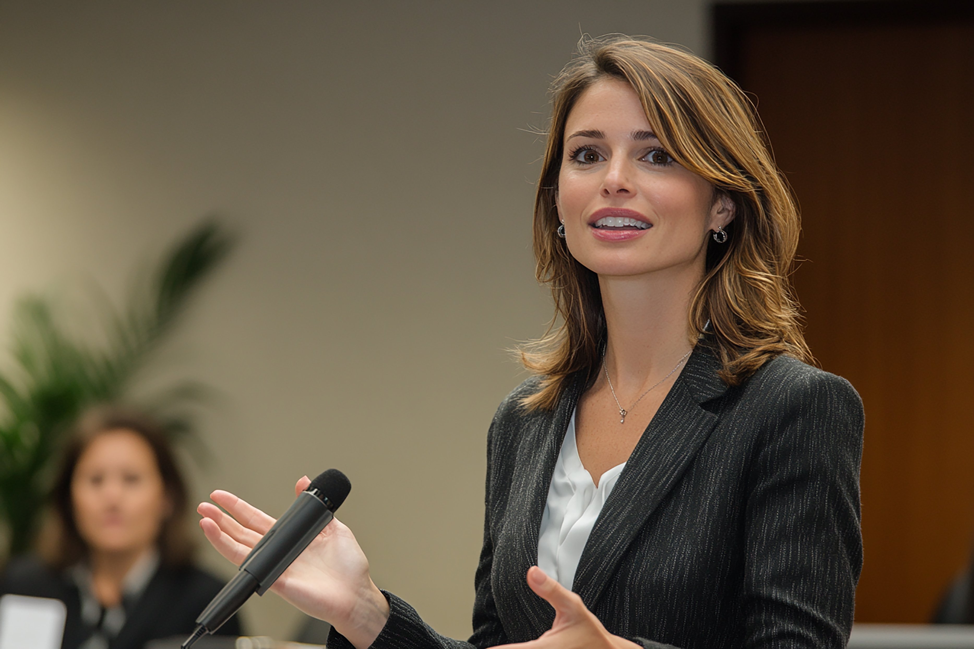 mujer-de-negocios-estadounidense-dando-una-presentacion-con-el-microfono-en-la-mano