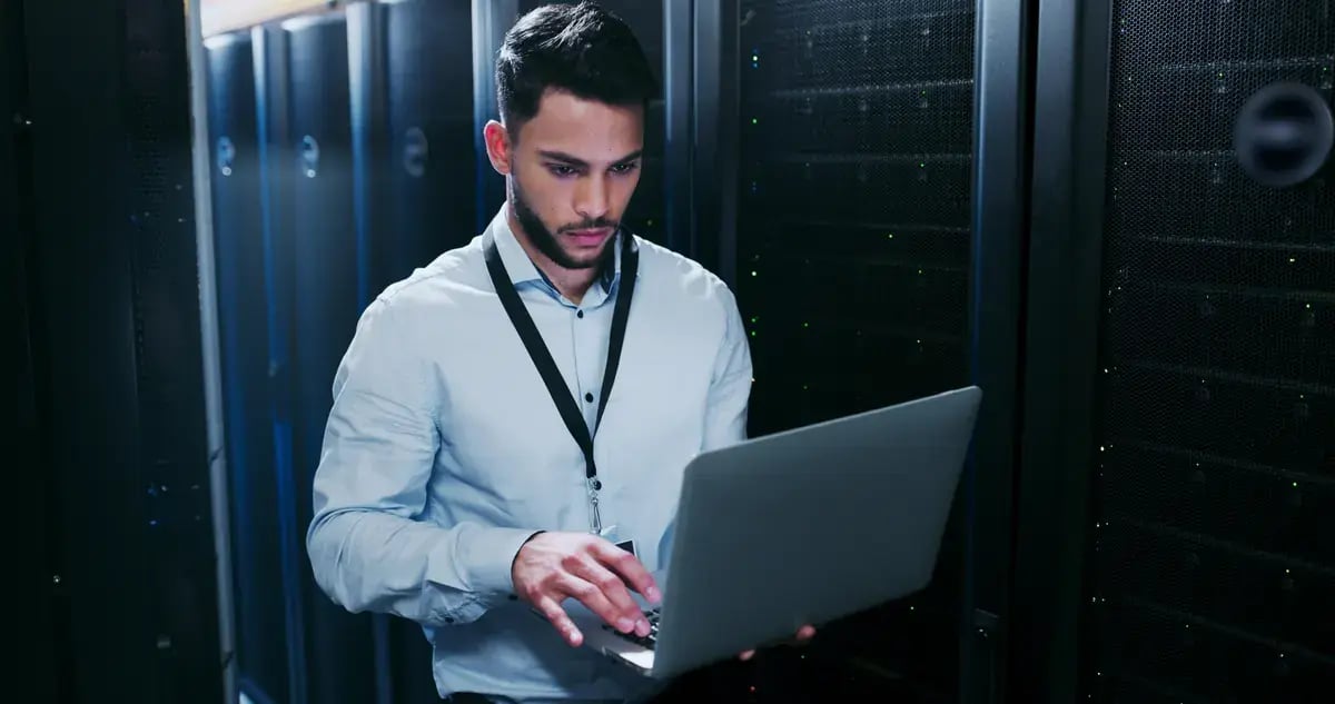 Especialista en seguridad informática trabaja con un portátil en un centro de datos