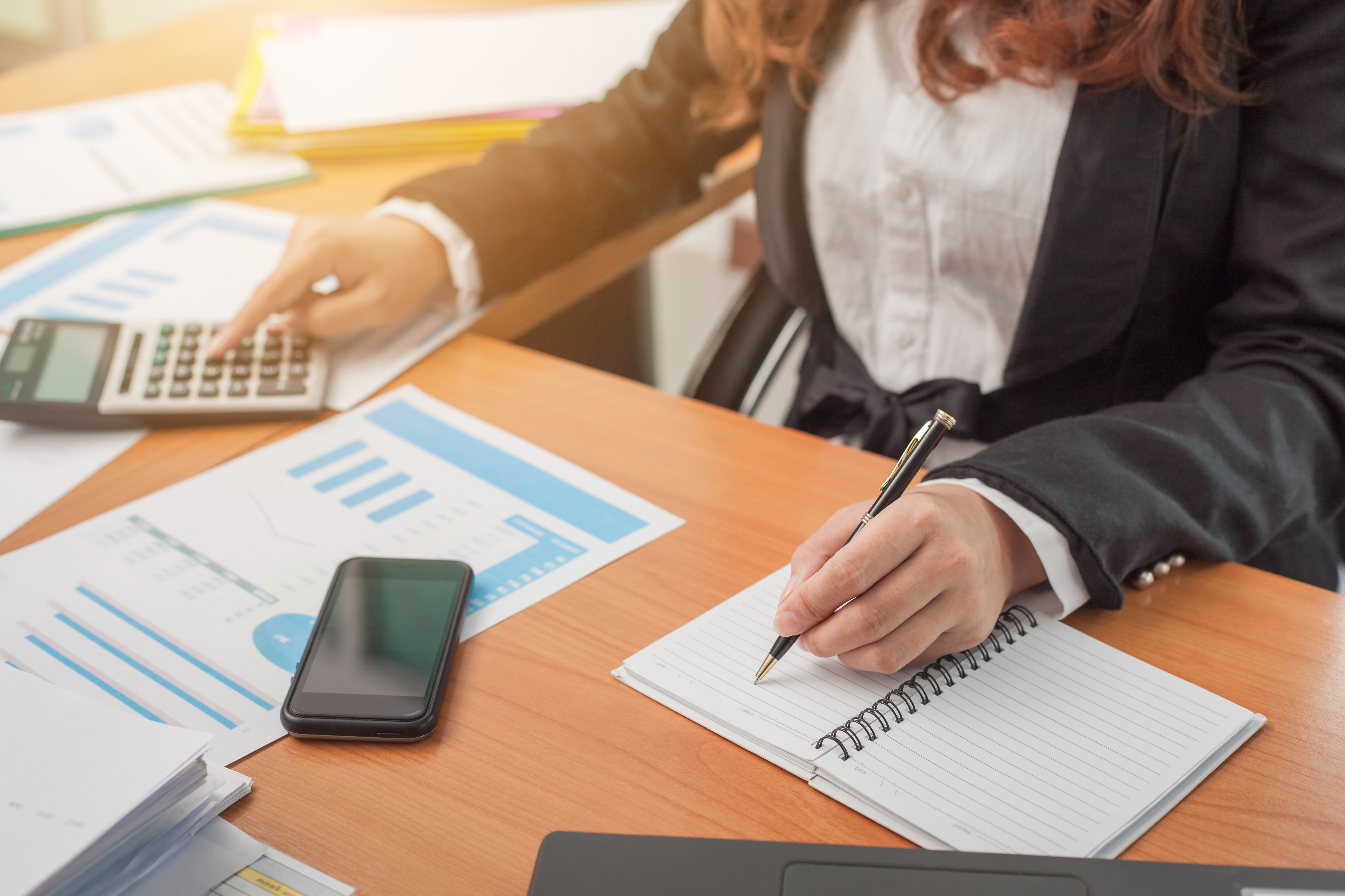 seccion-media-de-una-mujer-usando-el-telefono-movil-mientras-esta-sentada-en-la-mesa